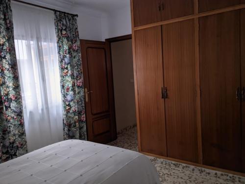 a bedroom with a bed and a dresser and a window at Casa de la Sirena in Baena