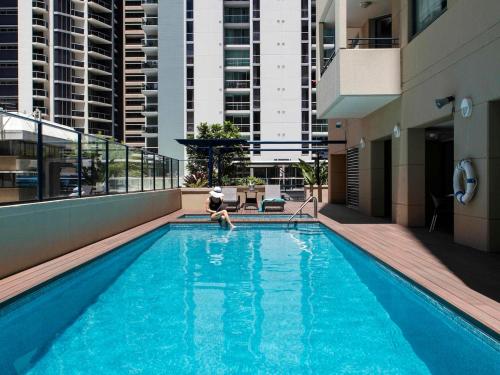 a person in a swimming pool in a building at CBD Two Bedrooms Apartment in Brisbane