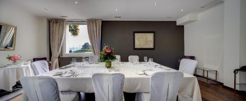 a dining room with white tables and white chairs at Romantik Hotel Mont Blanc au Lac in Morges