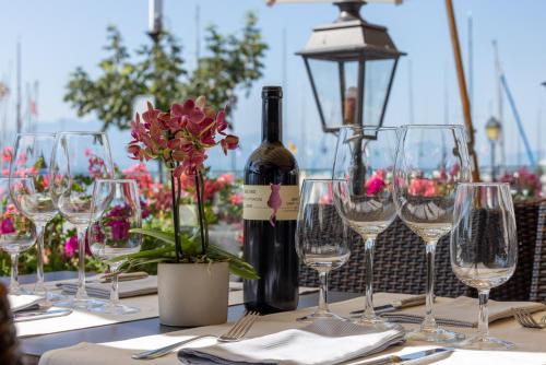 a table with a bottle of wine and wine glasses at Romantik Hotel Mont Blanc au Lac in Morges
