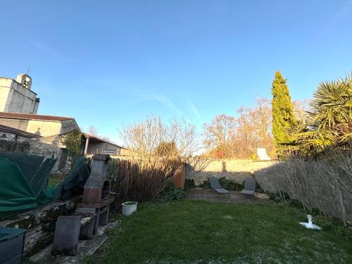 - un jardin avec deux chaises dans la cour dans l'établissement Au calme proche de La Rochelle, de la mer et du golf, à Nieul-sur-Mer