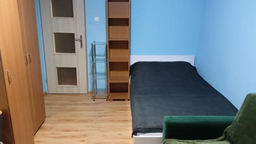 a bedroom with a bed and a green couch at Комната в трёхкомнатной квартире in Wrocław
