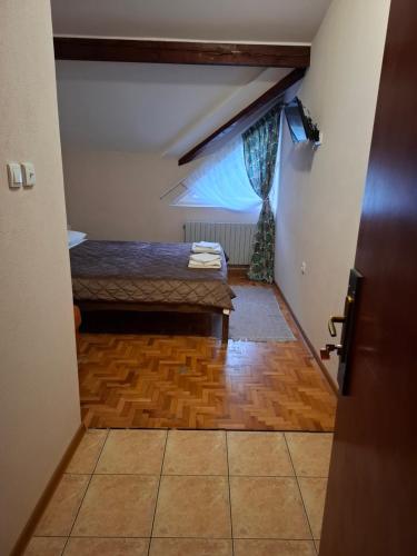 a attic room with a bed and a window at Hotel Koliba na Grza in Kilsura
