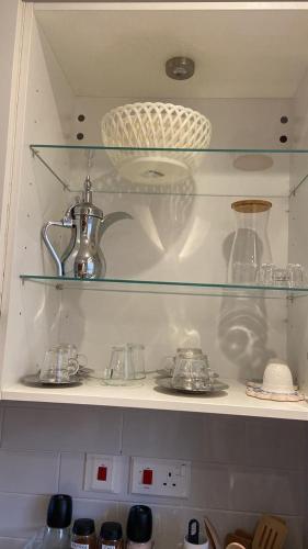 a shelf with dishes and vases on it at Sifah seaCottage in Muscat