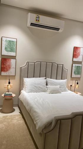 a bedroom with a large bed with white sheets at Sifah seaCottage in Muscat