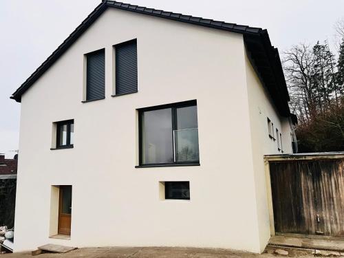 a white house with black windows at 2-Zimmerapartment an der Schweizer Grenze in Albbruck