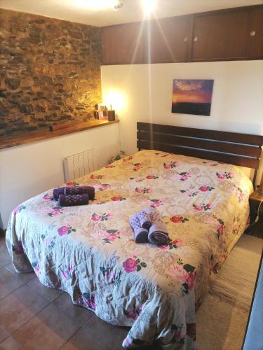 a bedroom with a bed with shoes on it at Bela Vista Alqueve - traditional stone house and private pool in Arganil