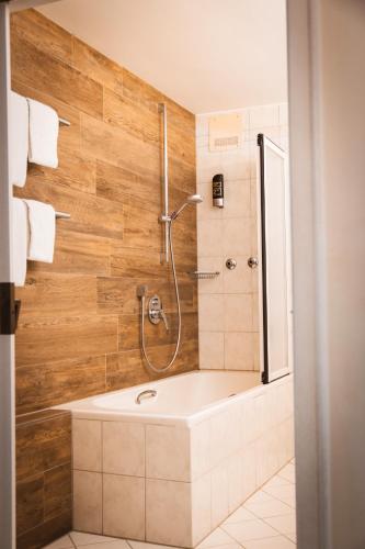 a bathroom with a shower and a bath tub at Sure Hotel by Best Western Rhoen Garden in Poppenhausen