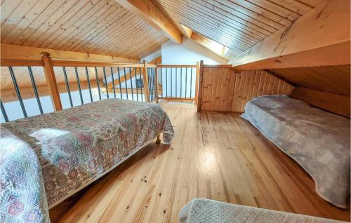 a bedroom with two beds in a room with wooden floors at Stunning Apartment In Usson-En-Forez in Usson-en-Forez