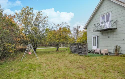 a yard next to a house with a swing at Stunning Home In Charlottenberg in Charlottenberg