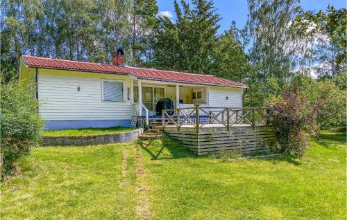 a small white house with a porch in a yard at Amazing Home In Herräng With Wifi in Herräng