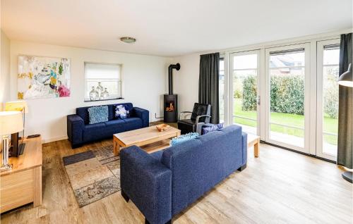 Una sala de estar con dos sofás azules y una mesa. en Grote Wiedenwoning 6P, en Giethoorn