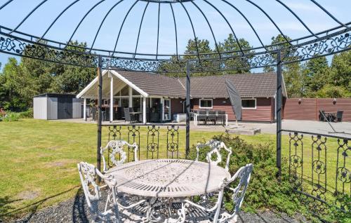 a table and chairs in a yard with a house at Awesome Home In Rødby With Sauna in Rødby