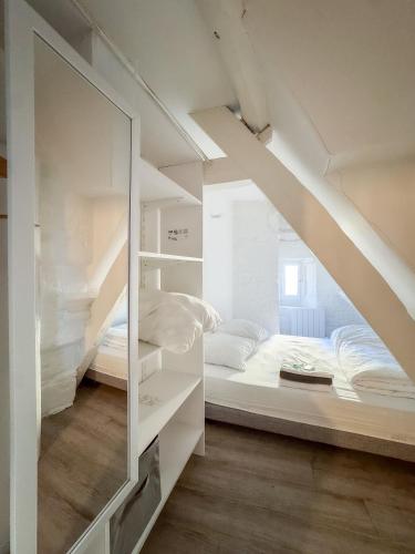 une chambre avec un lit superposé et un miroir dans l'établissement Luna, à Caen