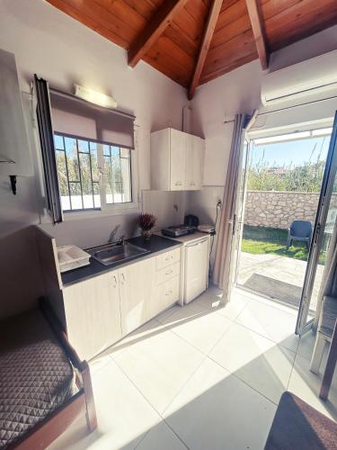 a kitchen with a sink and a door to a yard at PEDRO NAVARINO VII Laganas in Laganas