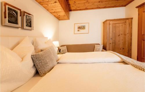 a bedroom with two white beds and a wooden ceiling at Ferienwohnung Im Walserhaus in Altenmarkt im Pongau