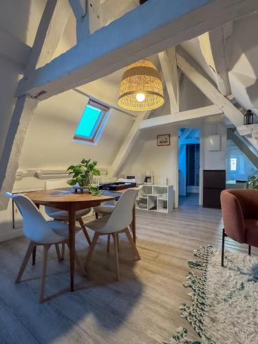 une salle à manger avec une table et des chaises en bois dans l'établissement Luna, à Caen