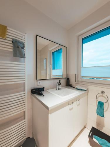 a bathroom with a white sink and a mirror at Nahe Messe - Privates Gästezimmer mit Bad in einer Wohnung in Cologne