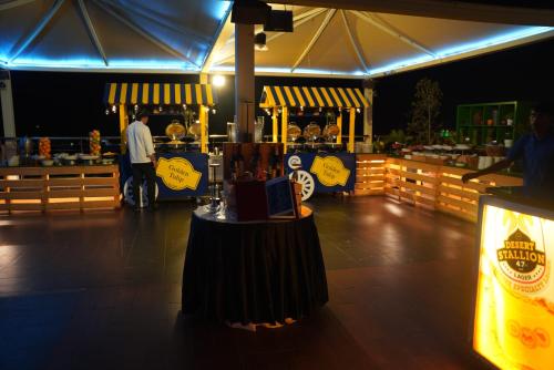 a man standing in front of a food stand at night at Golden Tulip Muscat in Muscat