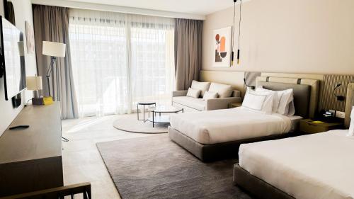 a hotel room with two beds and a couch at The G Einbay Golf Resort in Ain Sokhna