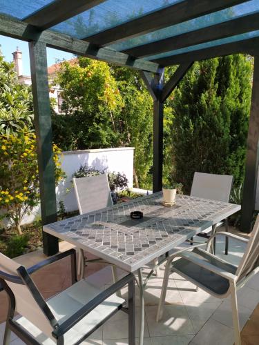 a table and chairs on a patio with a pergola at Apartments Rena & Filip, by the beach in Preko