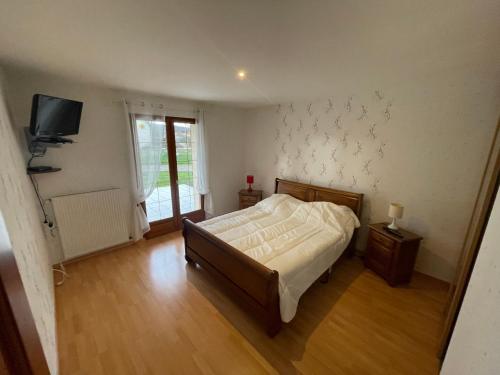 une chambre avec un lit et une télévision au mur dans l'établissement Chez Zabeth, à Chemilly-sur-Serein