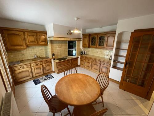 une grande cuisine avec une table et des chaises en bois dans l'établissement Chez Zabeth, à Chemilly-sur-Serein