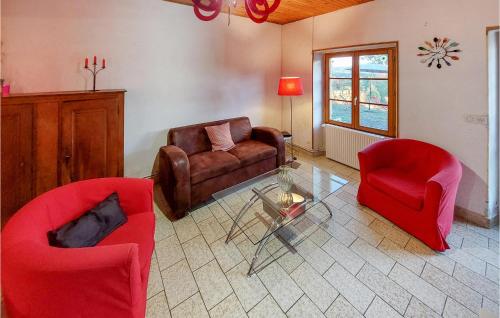 - un salon avec des chaises rouges et une table en verre dans l'établissement 4 Bedroom Beautiful Home In Lantriac, à Lantriac
