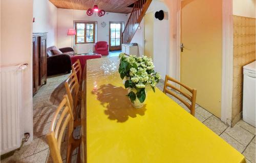 une table jaune avec un vase de fleurs sur elle dans l'établissement 4 Bedroom Beautiful Home In Lantriac, à Lantriac