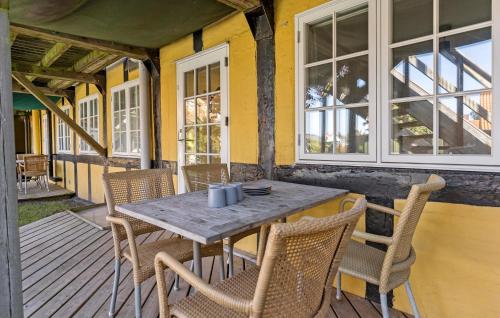 a wooden table and chairs on a porch at 2 Bedroom Awesome Apartment In Svaneke in Svaneke