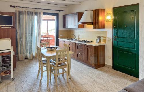 a kitchen with a green door and a table and chairs at 2 Bedroom Beautiful Home In Castelsardo in Castelsardo