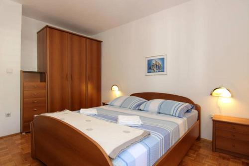 a bedroom with a large bed with blue pillows at Eco-Apartments with nice garden in Baška Voda