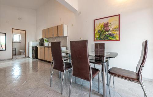 a dining room with a table and chairs and a kitchen at Two-Bedroom Apartment In Vir in Vir