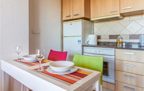 a kitchen with a table with two plates and wine glasses at Awesome Apartment In Villanueva Del Rio Seg in Villanueva de Río Segura