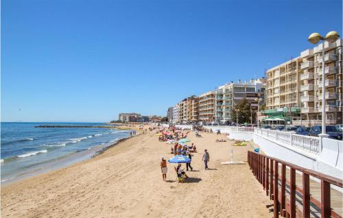 un groupe de personnes sur une plage avec des bâtiments dans l'établissement Lovely Apartment In Torrevieja, à Torrevieja