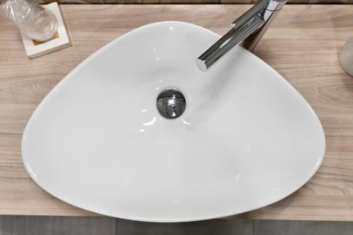 a white sink on a wooden counter top with at InCentro Comfort Suite - Lecce Selection in Lecce