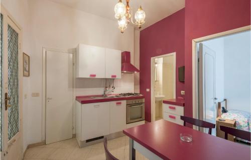 a kitchen with white cabinets and a red counter top at Trilo in Cattolica