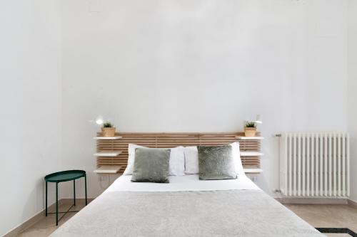 a bedroom with a white bed and a green chair at InCentro Comfort Suite - Lecce Selection in Lecce