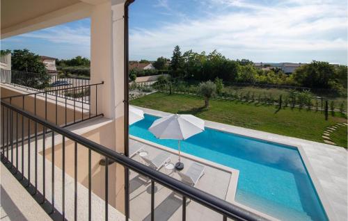 a balcony with a swimming pool and an umbrella at Villa Stella Smoljanci in Smoljanci