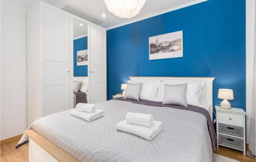 a blue bedroom with a large bed with white pillows at Stunning Apartment In Mali Losinj in Mali Lošinj
