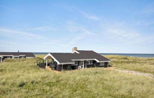 a house sitting on top of a grass covered hill at 3 Bedroom Ocean Front Home In Hjørring in Hjørring
