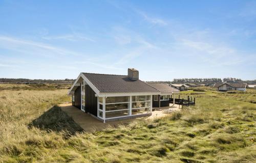 a small house in the middle of a field at 3 Bedroom Ocean Front Home In Hjørring in Hjørring