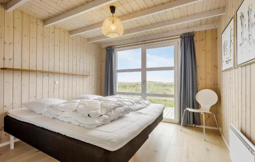 a bedroom with a large bed and a window at 3 Bedroom Ocean Front Home In Hjørring in Hjørring