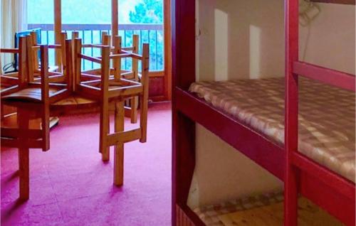 Cette chambre comprend 2 lits superposés avec des chaises et une table. dans l'établissement Cozy Apartment In Orcières With Wifi, à Orcières