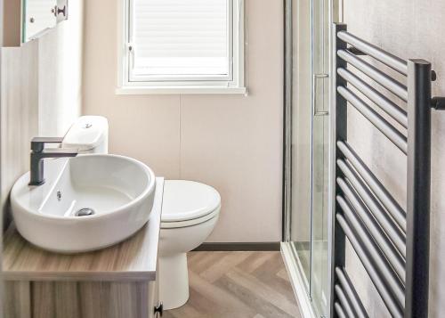 a bathroom with a sink and a toilet at Golden Palm Resort in Chapel Saint Leonards