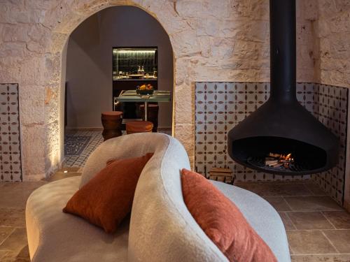 a living room with a fireplace and a couch at Trulli di V E N E R E in Castellana Grotte