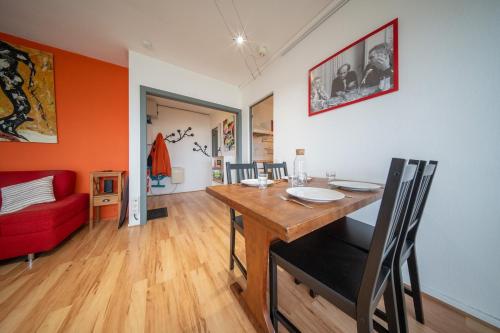 - une salle à manger avec une table et un canapé rouge dans l'établissement Magnifique appartement Parking de la Marne, à Mulhouse