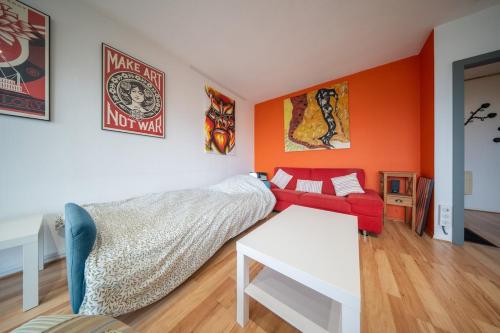 un salon avec un canapé rouge et une table dans l'établissement Magnifique appartement Parking de la Marne, à Mulhouse