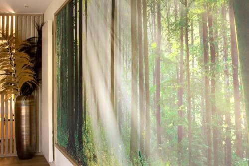 a window with a mural of a forest at LA CHENEAUDIÈRE - Hôtel Spa - Relais & Châteaux - Restaurant étoilé in Colroy-la-Roche