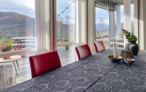 a dining room with a table and red chairs at 3 Bedroom Awesome Home In Nordfjordeid in Nordfjordeid